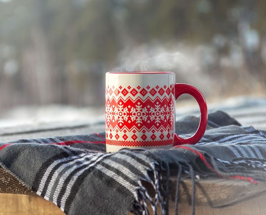 a steaming coffee christmas mug on a blanket