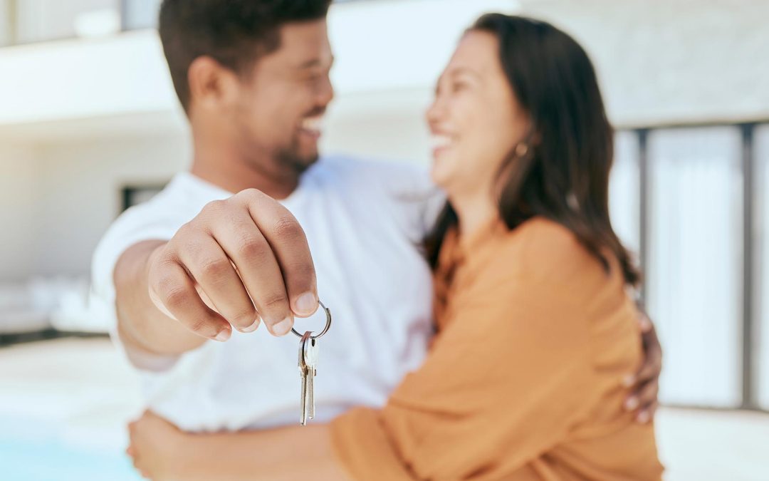 couple hand and key to new real estate property